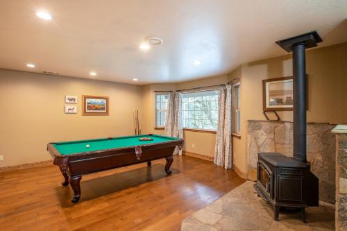 a living room with a pool table and a wood stove at Mountain Retreat with Hot Tub & Pool Table - 1 hour from Squaw Valley Resort! in Colfax