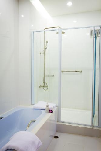 a bathroom with a tub and a shower at Sriracha Orchid Hotel in Si Racha