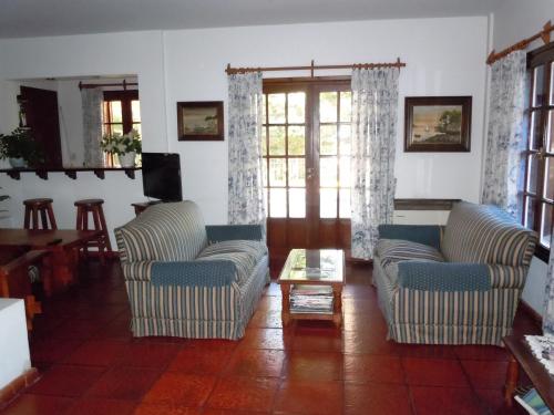 a living room with two chairs and a coffee table at Las Araucarias in Pinamar