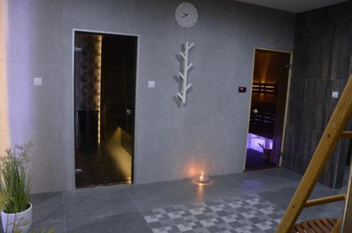 a room with a clock on the wall and a candle at Hotel Roztocze in Zwierzyniec