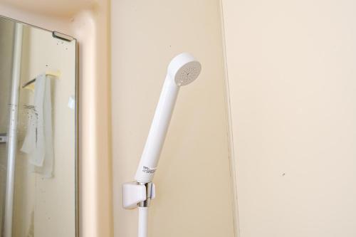 a toothbrush hanging on a wall next to a mirror at 渡邊民泊 in Nagasaki