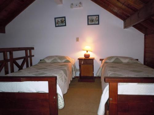 a bedroom with two beds and a lamp on a table at Las Araucarias in Pinamar
