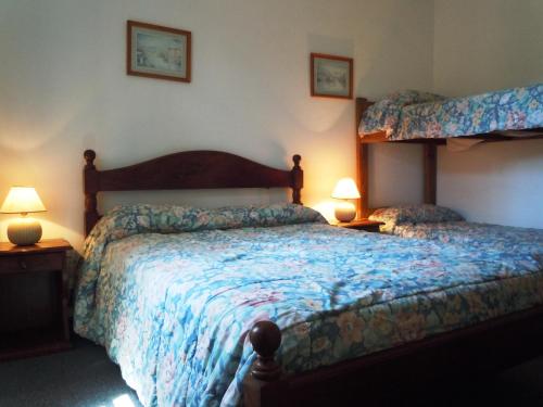 a bedroom with a large bed and two lamps at Las Araucarias in Pinamar