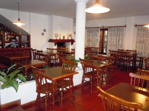 an empty restaurant with wooden tables and chairs at Las Araucarias in Pinamar