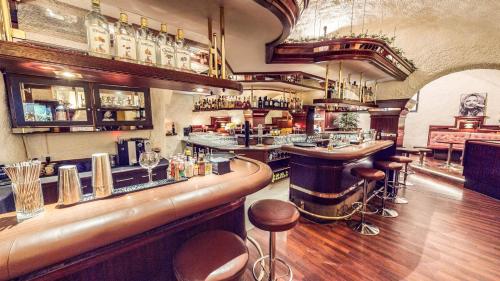 a bar with a counter and stools in a room at Schweizerhof in Mels