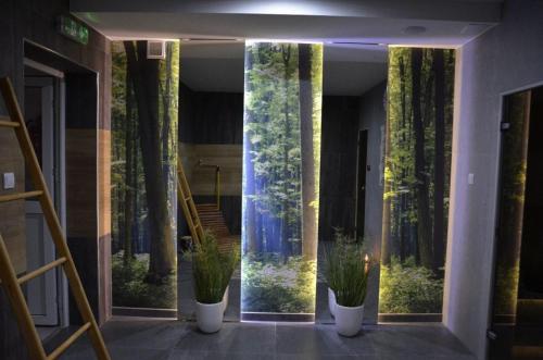 a hallway with plants in the middle of a building at Hotel Roztocze in Zwierzyniec