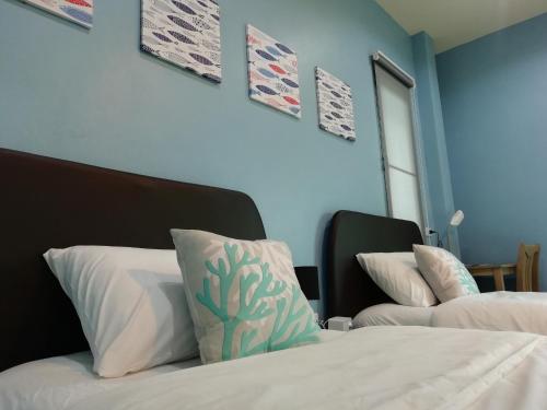 two beds in a room with blue walls at Morinaka Craftfe & Poshtel in Ban Na Muang