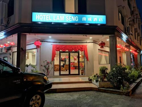 un letrero de hotel inclinada frente a un edificio en Hotel Lam Seng en Pantai Remis