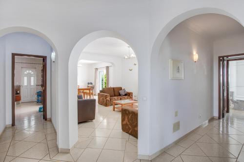 un soggiorno con pareti bianche e un arco di Casa das Romanzeiras a Carvoeiro