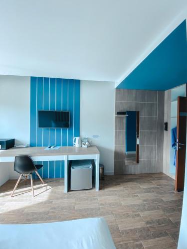 a room with a desk and a blue wall at The Galla Hotel in Ranong