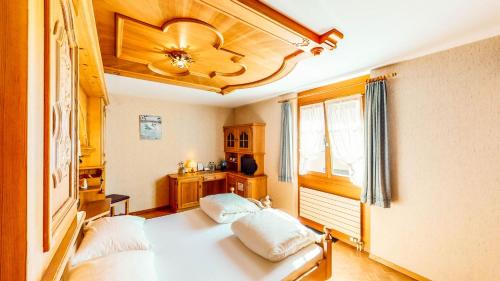 Schweizerhof في Mels: غرفة نوم بسريرين ومروحة سقف