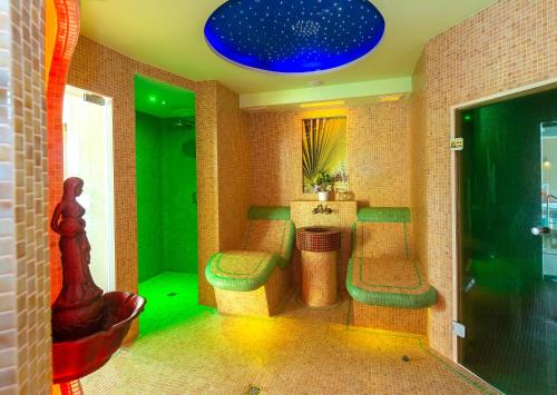 a room with a bar with green lighting and stools at Dworek Morski SPA & Wellness in Mielno
