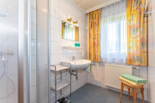 ein Bad mit einem Waschbecken und einer Dusche in der Unterkunft Mussbachhof in Saalfelden am Steinernen Meer