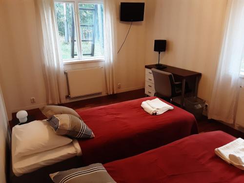 EuraにあるVilla Majatalotのベッドルーム1室(ベッド2台、テレビ、窓付)