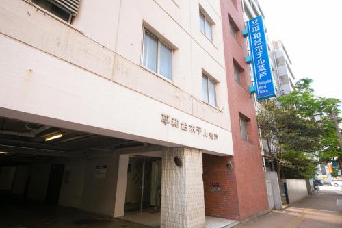 a building with a sign on the side of it at Heiwadai Hotel Arato in Fukuoka