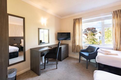 a hotel room with a desk and a mirror at Parkmore Hotel & Leisure Club, Sure Hotel Collection by BW in Stockton-on-Tees