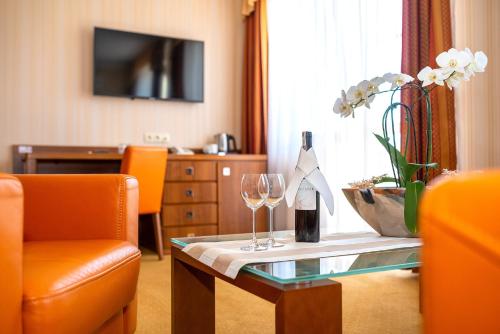 een woonkamer met een tafel met twee glazen wijn bij Dworek Morski SPA & Wellness in Mielno