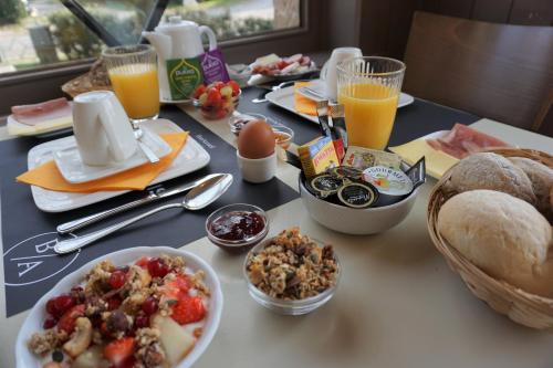 a table with breakfast foods and drinks on it at Hotel Bon Accueil in De Haan