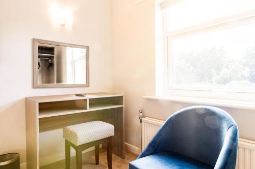 a room with a blue chair and a mirror at Parkmore Hotel & Leisure Club, Sure Hotel Collection by BW in Stockton-on-Tees