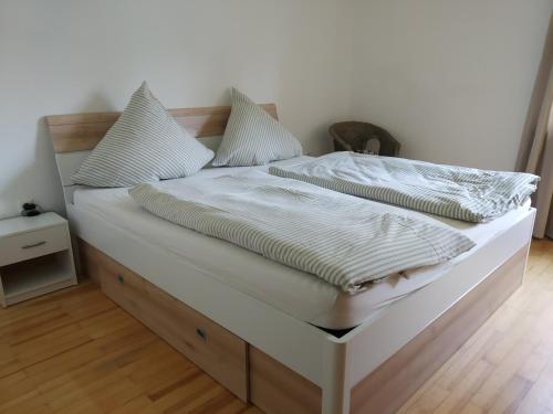 un letto bianco con lenzuola e cuscini bianchi di Ferienwohnung Betz a Riedenburg