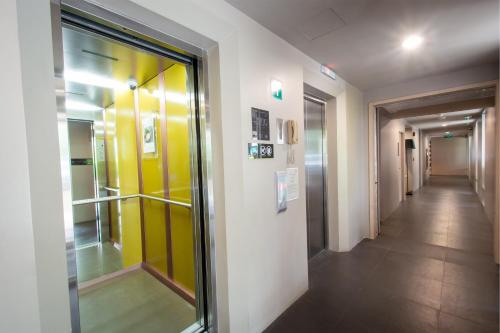 a hallway in a building with yellow and white walls at Lemontea Hotel Bangkok in Bangkok