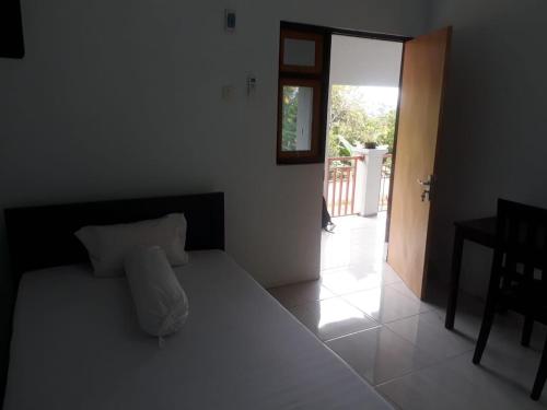 - une chambre avec un grand lit blanc dans l'établissement KoolKost At Malalayang Manado Minimum Stay 6 Nights, à Malalayang