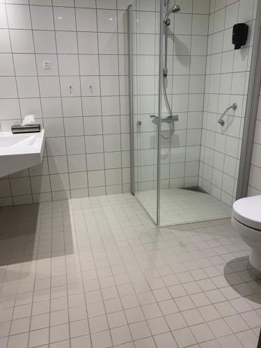 un bagno con doccia, WC e lavandino di Home Hotel Helma a Mo i Rana