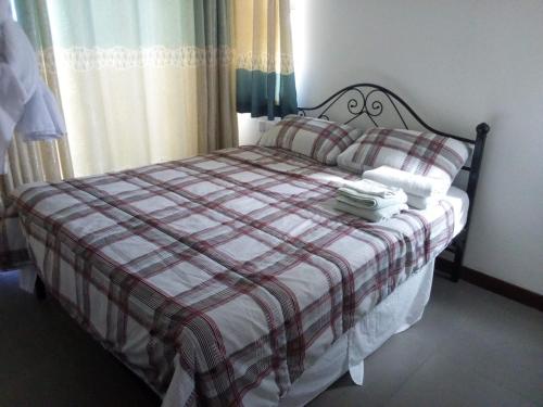 a bedroom with a bed with a checkeredkered bedspread at Sultan Palace in Kilifi