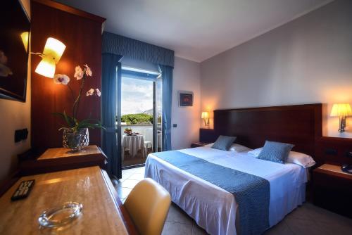 una camera d'albergo con letto, tavolo e finestra di Hotel Le Palme a Paestum