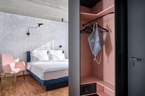a bedroom with a bed and a pink wall at URBAN LOFT Cologne in Cologne