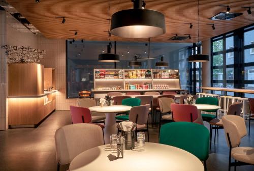 un restaurante con mesas y sillas y un bar en URBAN LOFT Cologne en Colonia
