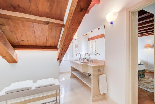 a bathroom with a sink and wooden ceilings at Master Venice Apartments in Venice