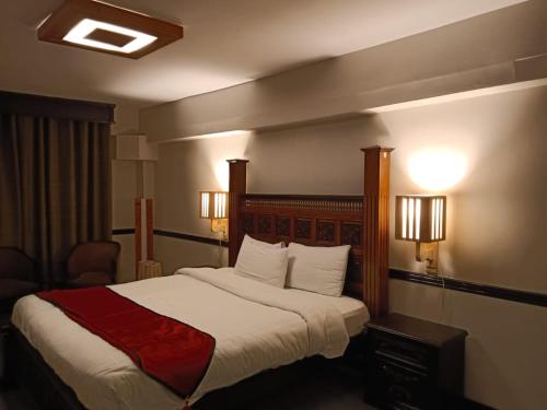 Cama en habitación de hotel con 2 luces en Shangrila Hotels & Resorts Changla Gali en Abbottābād