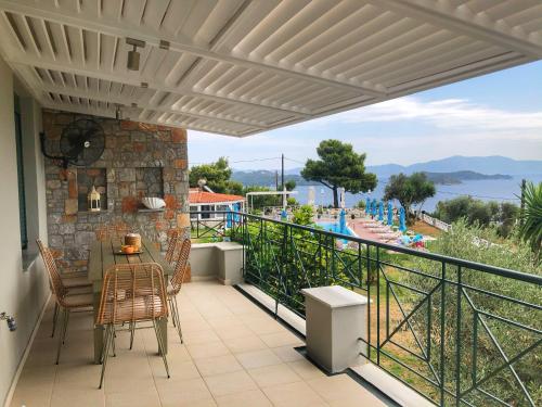 a patio with a table and chairs on a balcony at Azzurro in Skiathos Town