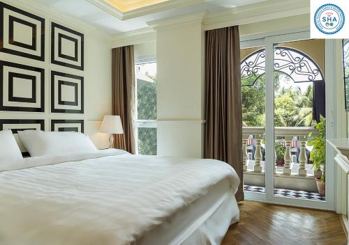ein Schlafzimmer mit einem Bett und einem großen Fenster in der Unterkunft LA49 Hotel - SHA Certified in Bangkok