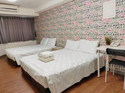 dwa łóżka w pokoju z ceglaną ścianą w obiekcie Sleep Taipei Hotel - Nanya w Tajpej