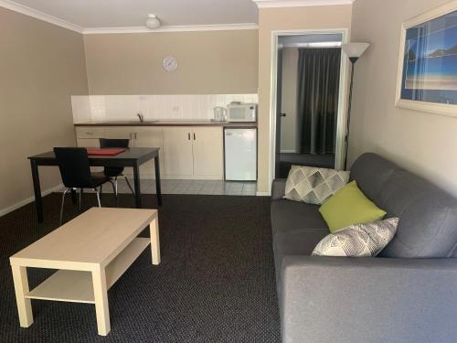a living room with a couch and a table and a kitchen at Studio32 in Albany