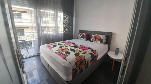 a bedroom with a bed with a comforter on it at City Center Comfortable Studio Apartment in Kavála