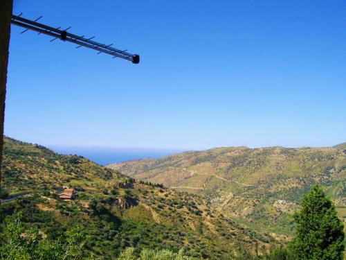 a view of a mountain with the ocean in the background at L'Uliveto in Reitano