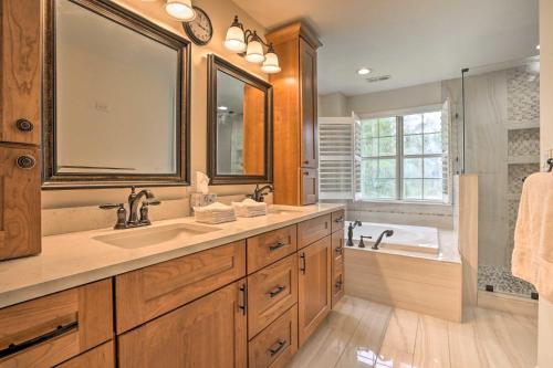 a bathroom with a sink and a tub and a mirror at Pet-Friendly Suburban Escape with Deck and Grill! in Wando