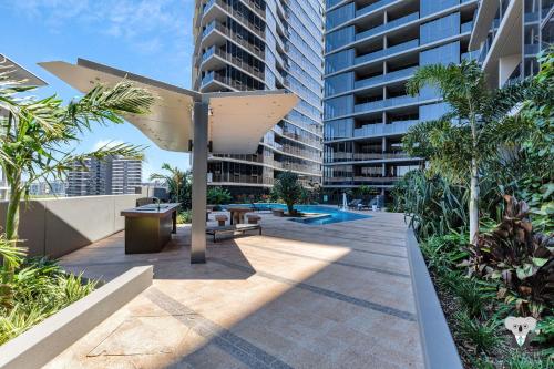 a patio with a umbrella in front of a building at KOZYGURU SOUTH BRISBANE KOZY 1BED APT + FREE PARKING QSB001 in Brisbane