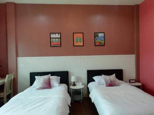 two beds sitting next to each other in a room at Morinaka Craftfe & Poshtel in Ban Na Muang