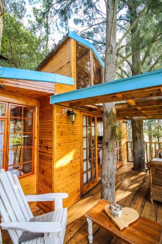 a cabin with two chairs on a wooden deck at Vindoux Tree House Guest Farm & Spa in Tulbagh