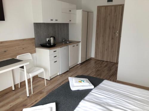 a room with a kitchen and a bed and a table at Willa Wena in Ustka