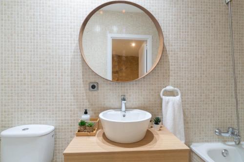 y baño con lavabo y espejo. en Terra Boutique Apartment, en Girona