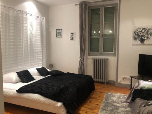 - une chambre avec un lit et une couverture noire dans l'établissement L'hommage, à Sarlat-la-Canéda