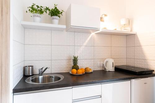 a kitchen with a sink and fruits on a counter at Willa Wena in Ustka