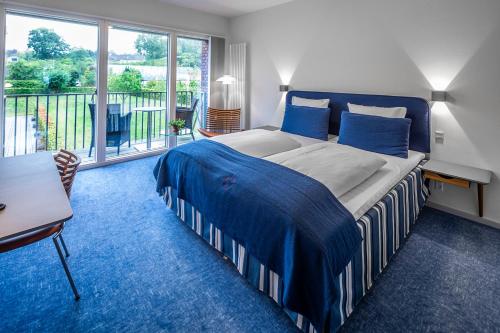 Un pat sau paturi într-o cameră la Molskroen Strandhotel