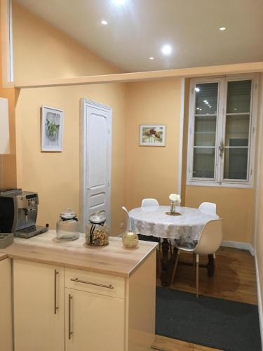 une cuisine avec une table et des chaises dans une pièce dans l'établissement L'hommage, à Sarlat-la-Canéda