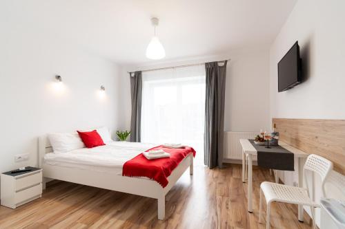 a bedroom with a bed and a desk and a television at Willa Wena in Ustka